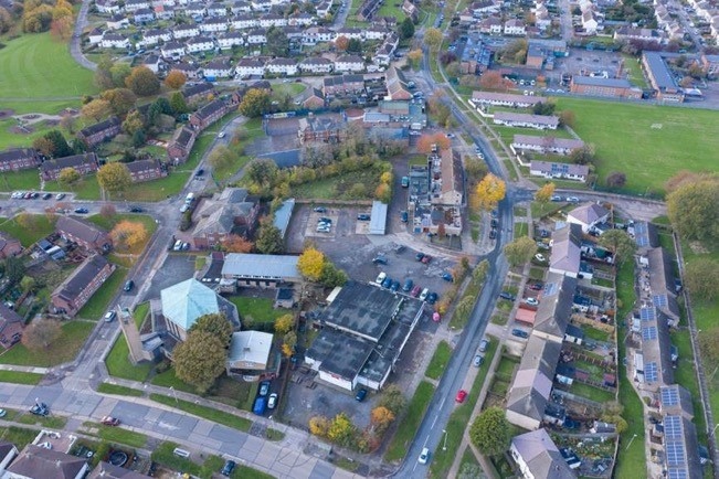 This image: aerial photo of Stocking Farm Neighbourhood Centre, taken from the east.
								The map: the map shows the buildings in and around the site, highlighted in different colours based on their use.